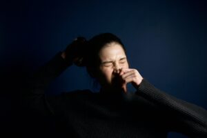 Person sneezing illustrating the importance of the “Stop Sneeze to Wheeze” initiative in combating Allergic Rhinitis and Asthma